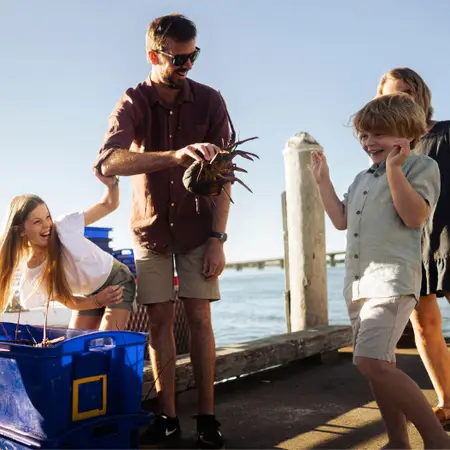 A family gathered around, with dad holding a crayfish